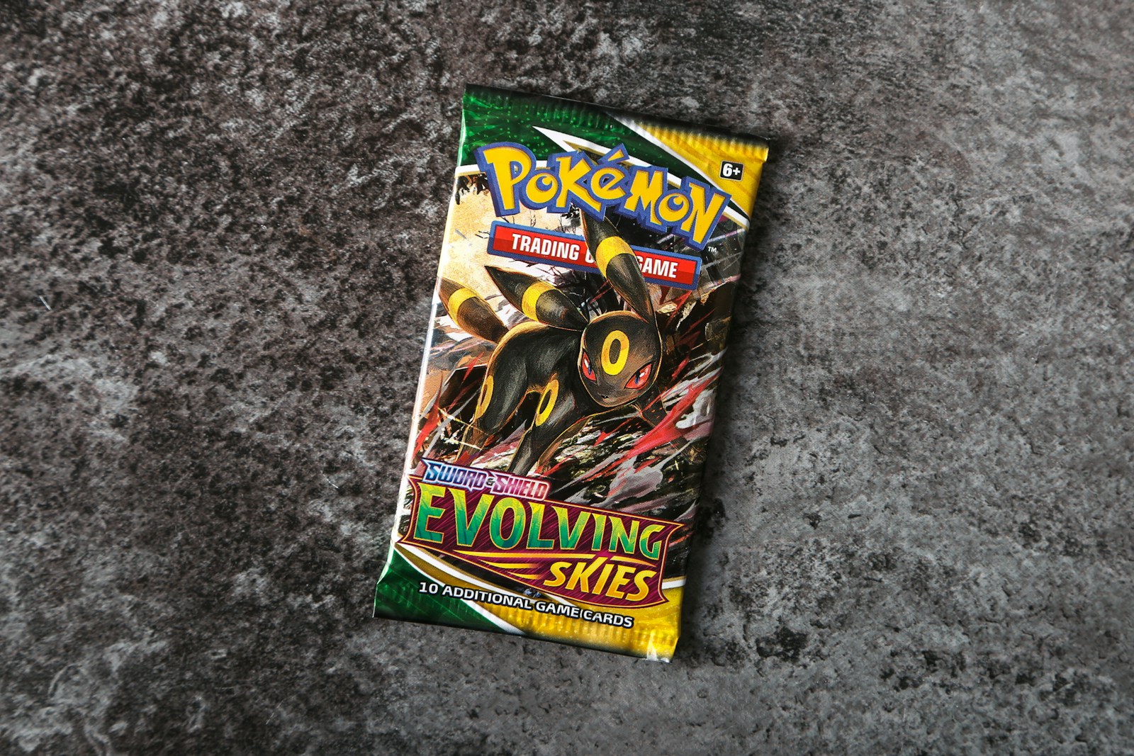 Englischer Pokémon-Booster Evolving Skies mit Nachtara-Motiv auf grauer Oberfläche; illustratives Foto.